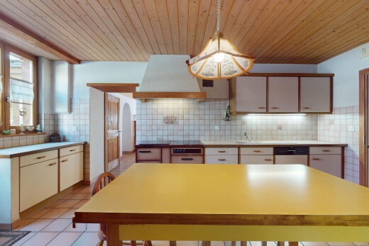 küche mit holzdecke, dunstabzugshaube, natürliches licht, küchenrückwand beim herd, und gewölbte gehwege