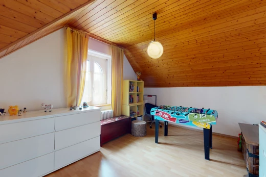 salle de jeux avec parquet, lumière naturelle, et plafond voûté