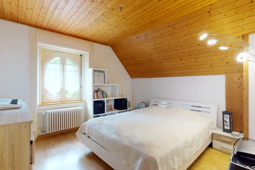 chambre à coucher avec parquet, plafond voûté, lumière naturelle, et radiateur