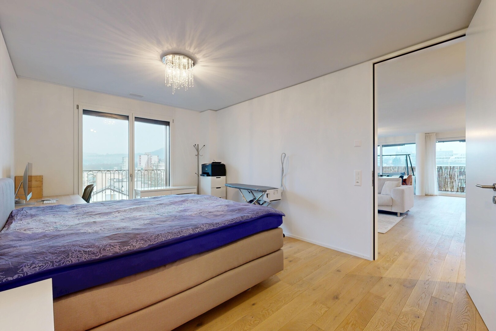room with light wood-style flooring, access to outside, and a chandelier