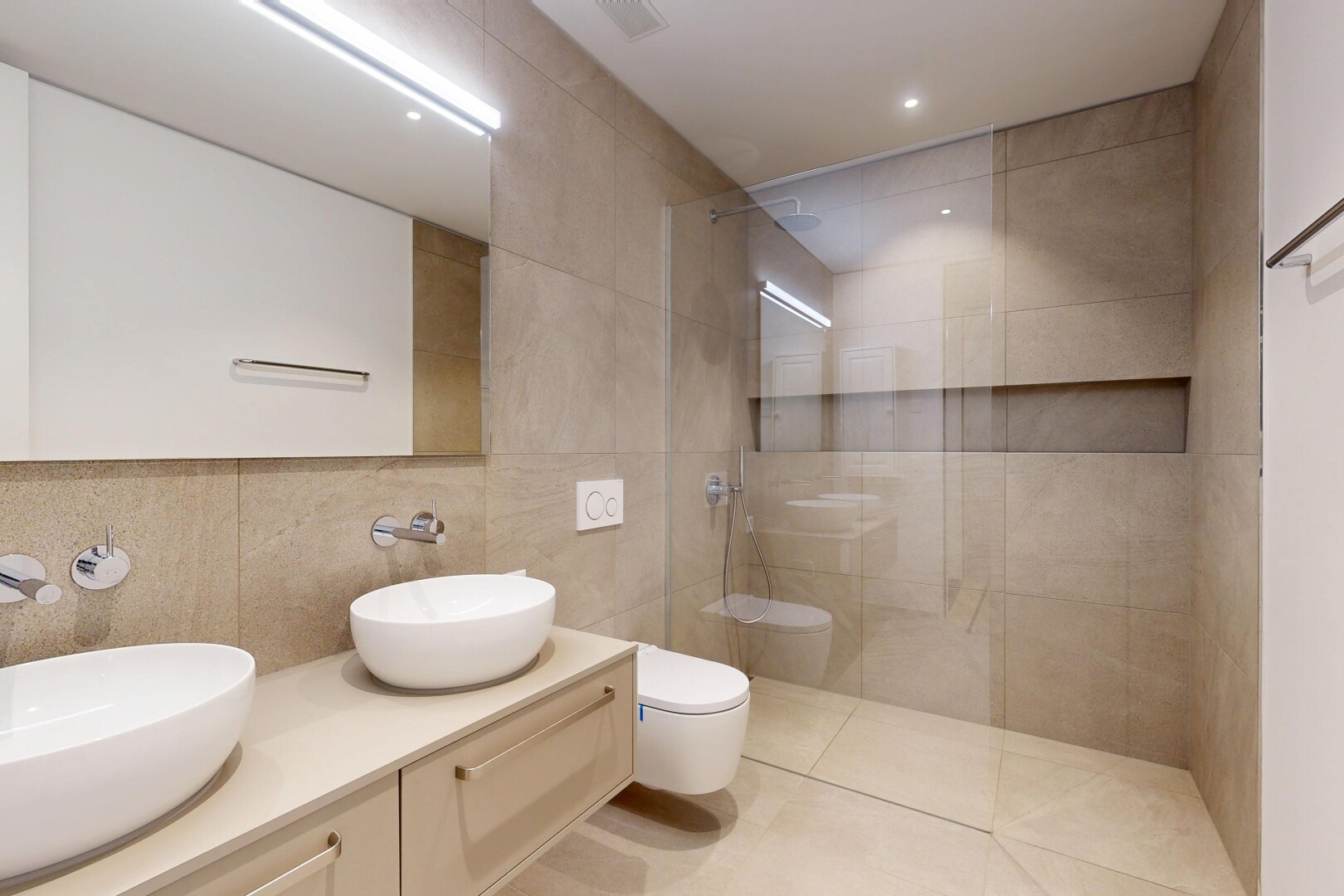 bathroom featuring a walk in shower, double vanity, tile walls, recessed lighting, and light tile patterned floors