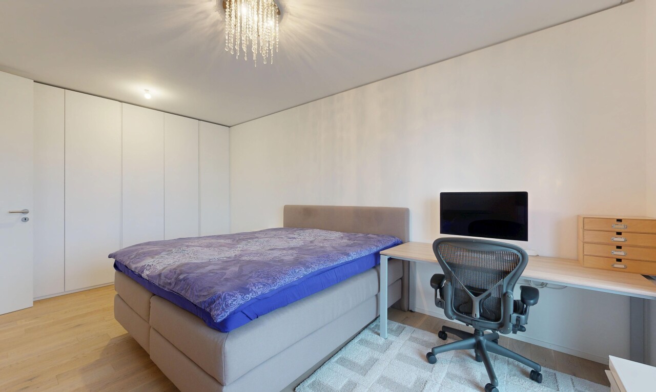 room / bedroom featuring light wood-style flooring, a desk, and suspended lighting