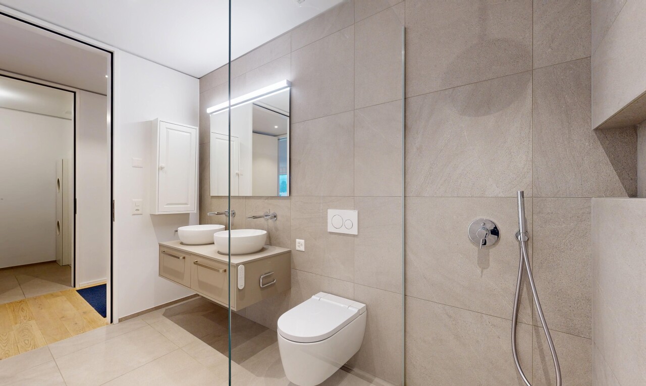 full bath with double vanity, tile walls, tile patterned flooring, and walk in shower