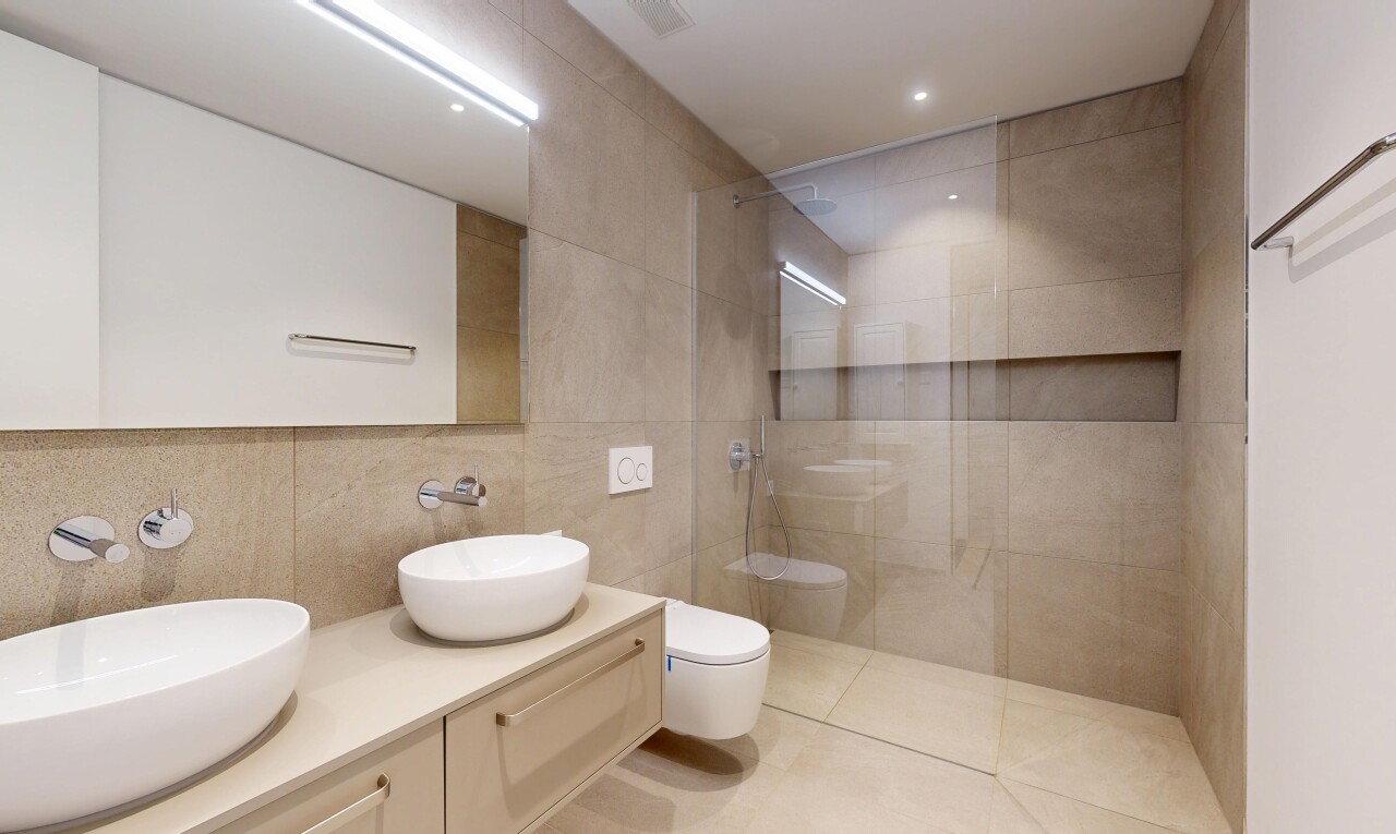 bathroom featuring a walk in shower, double vanity, tile walls, recessed lighting, and light tile patterned floors