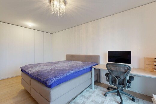 chambre avec wood finish floor, sol en finition bois, télévision, inside property, et espace bureau