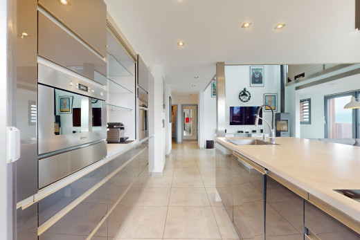 küche mit fernseher, fliesenboden, geschirrspülmaschine, natürliches licht, und waschbecken