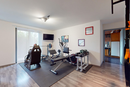 fitnessstudio mit parkettboden, natürliches licht, und fernseher