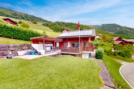 außenansicht mit deck, rasen, pergola, solaranlage, und blick auf die berge
