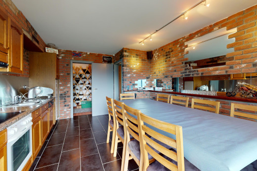 küche mit ziegelwand, bogenförmige schränke, deckenbeleuchtung, fliesenboden, und ofen