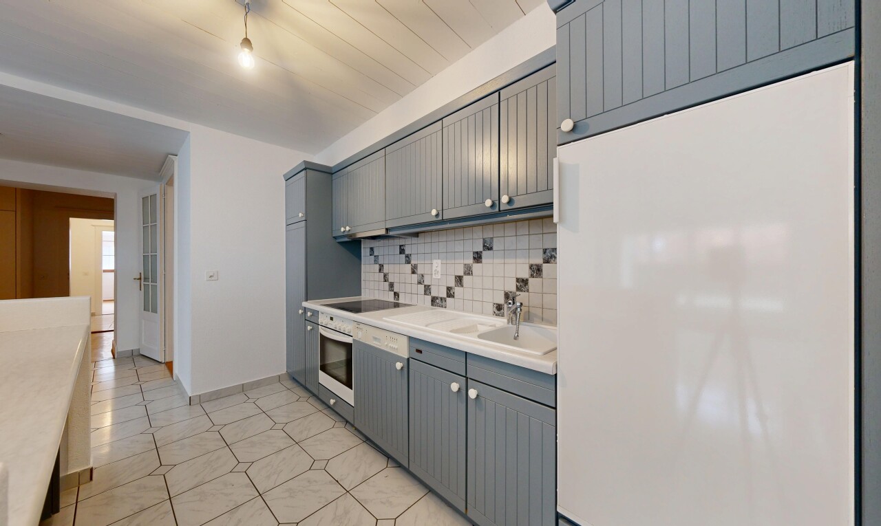 kitchen featuring freestanding refrigerator, light countertops, gray cabinetry, stainless steel oven, and backsplash