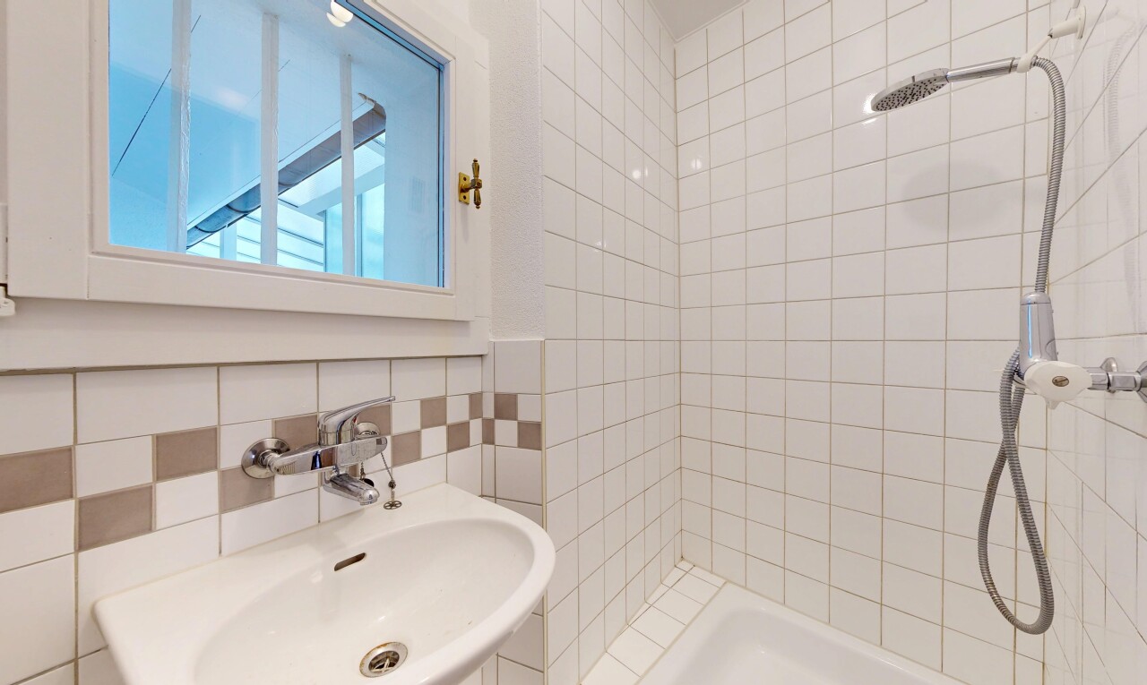 bathroom with a tile shower and tile walls