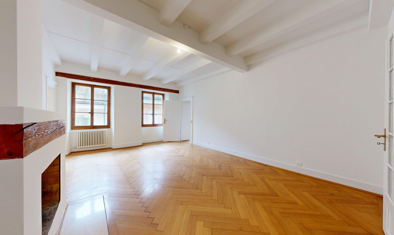 unfurnished room with parquet flooring, radiator, beam ceiling, and a fireplace