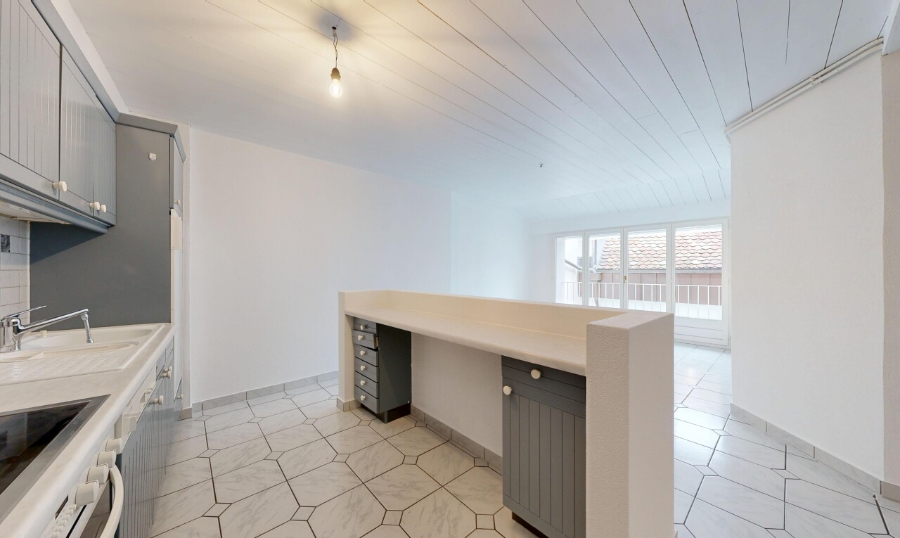 kitchen with gray cabinetry, light countertops, built in study area, wooden ceiling, and oven