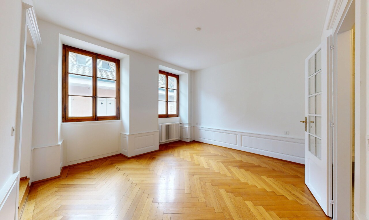 unfurnished room featuring parquet flooring, wainscoting, a decorative wall, and radiator heating unit