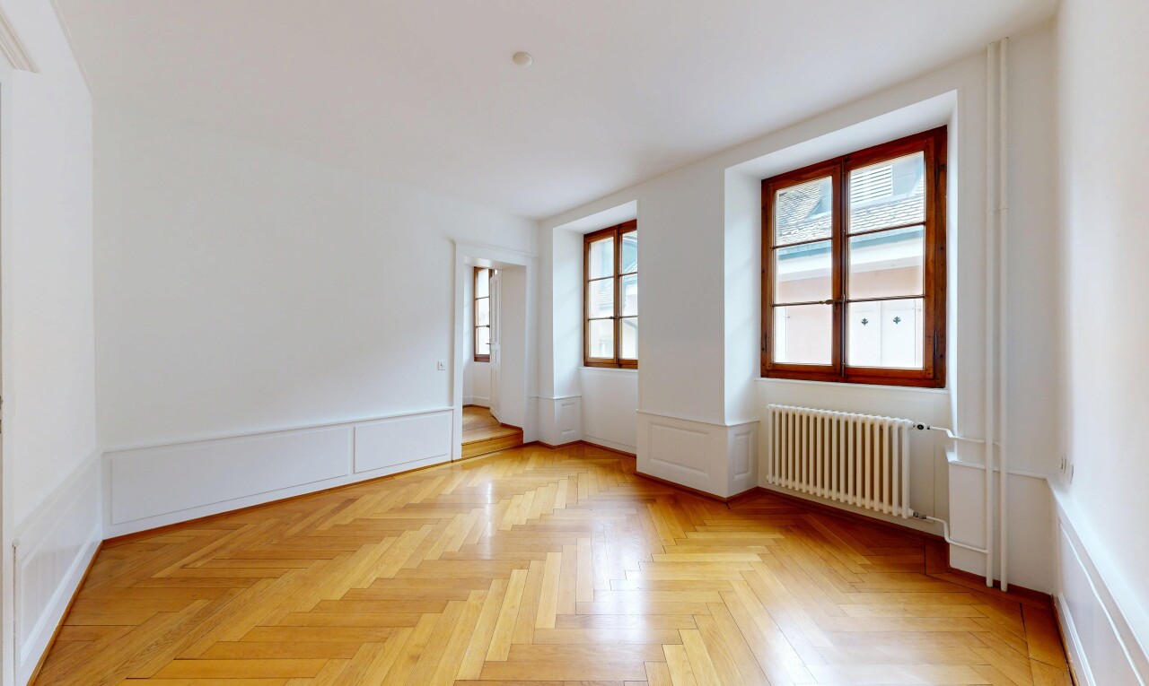 spare room with radiator heating unit, wainscoting, parquet floors, and a decorative wall