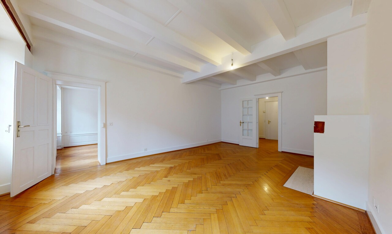 empty room featuring parquet floors and beamed ceiling