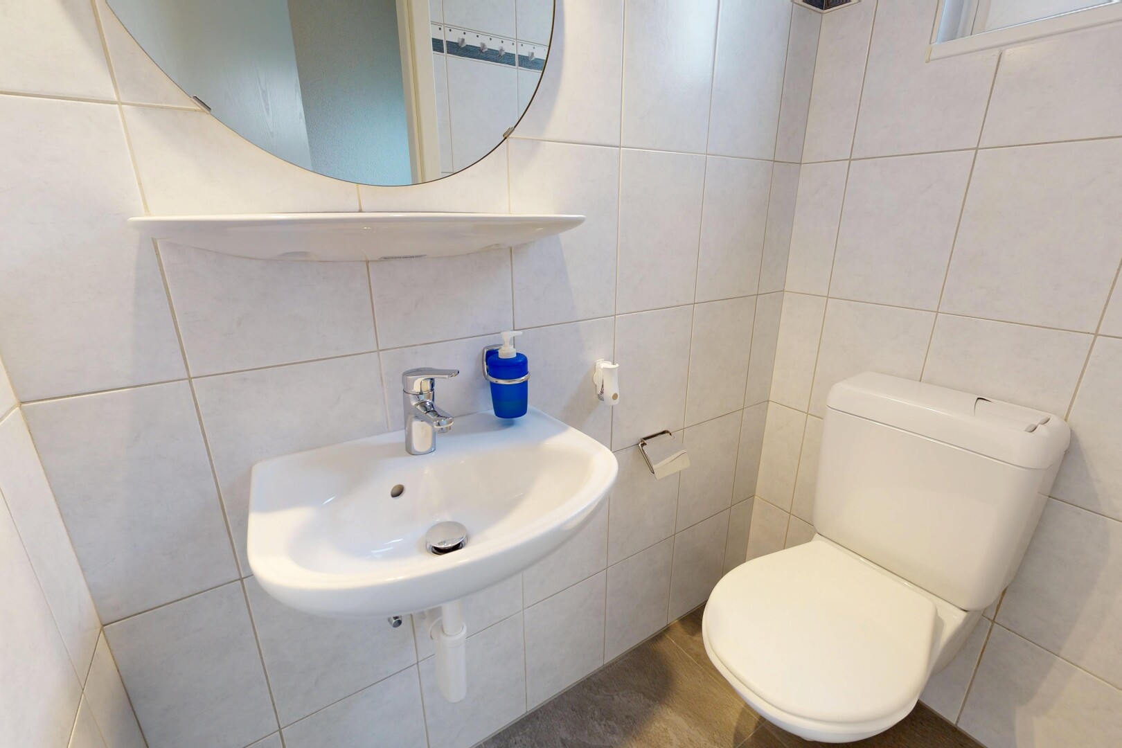 salle de bains avec toilette, miroir, mur en carrelage, tile wall, et inside property