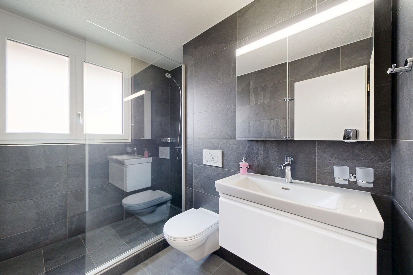 salle de bains avec lavabo (ou coiffeuse selon le contexte), tile wall, mur en carrelage, natural light, et salle de bain complète