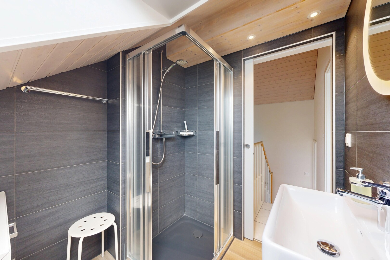 salle de bains avec évier, douche, tile wall, mur en carrelage, et salle de bain complète