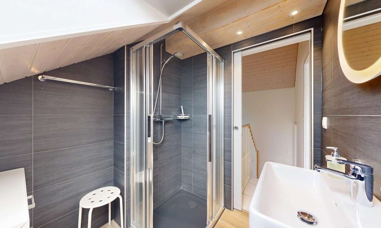 salle de bains avec évier, douche, tile wall, mur en carrelage, et salle de bain complète