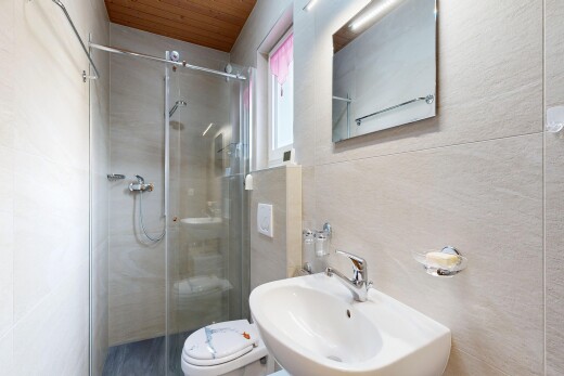 bathroom featuring a stall shower, wooden ceiling, and tile walls
