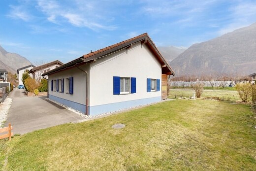 view of home with a mountain view, stucco siding, and a lawn