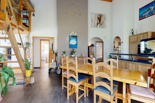 salle à manger avec high ceiling, plafond haut, passages en arc, drywall, et cloison sèche