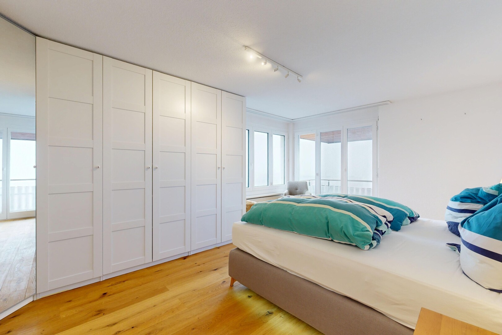chambre avec sol en finition bois, wood finish floor, inside property, lumière naturelle, et natural light
