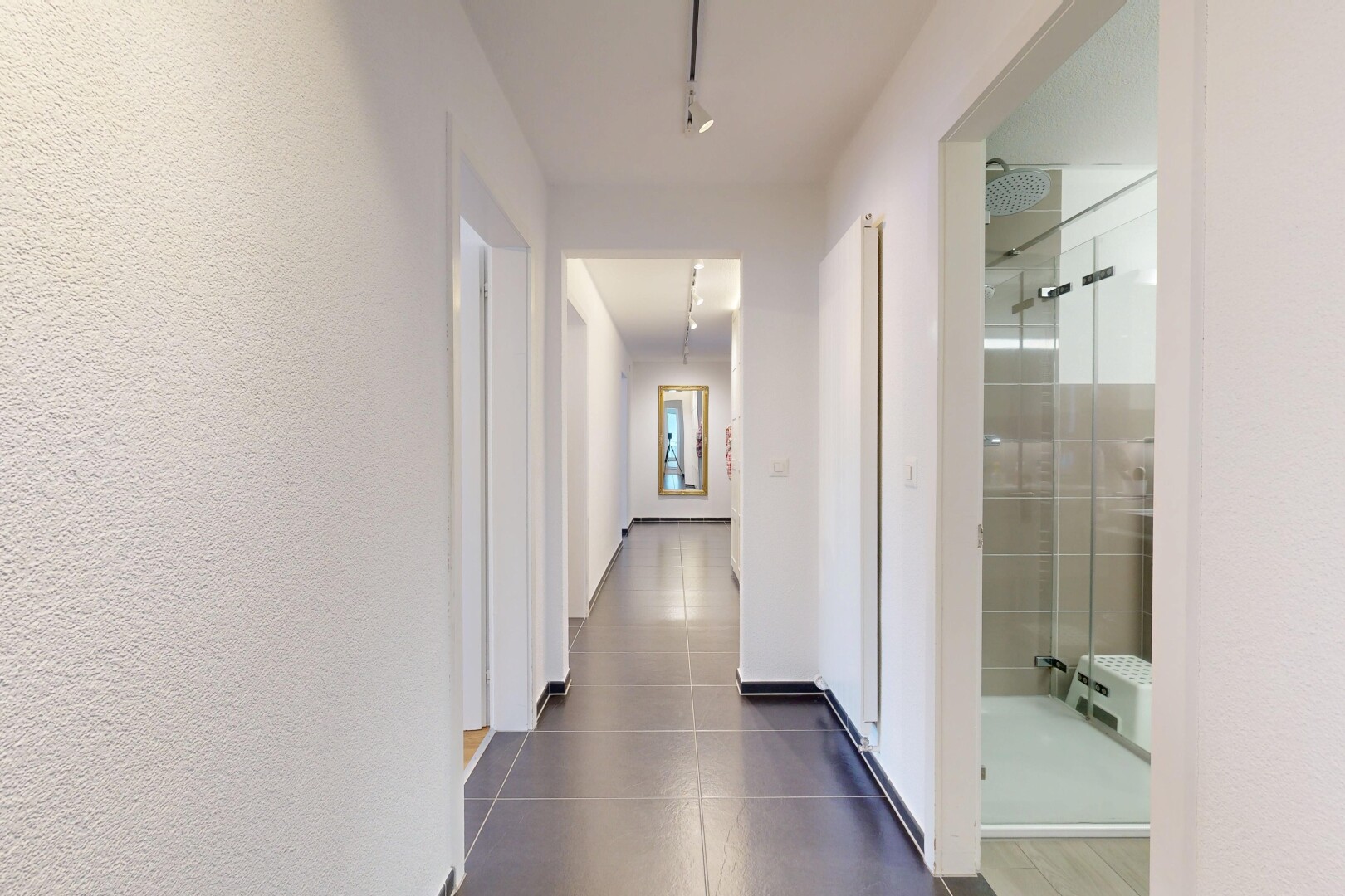 couloir avec inside property, éclairage sur rail, et track lighting