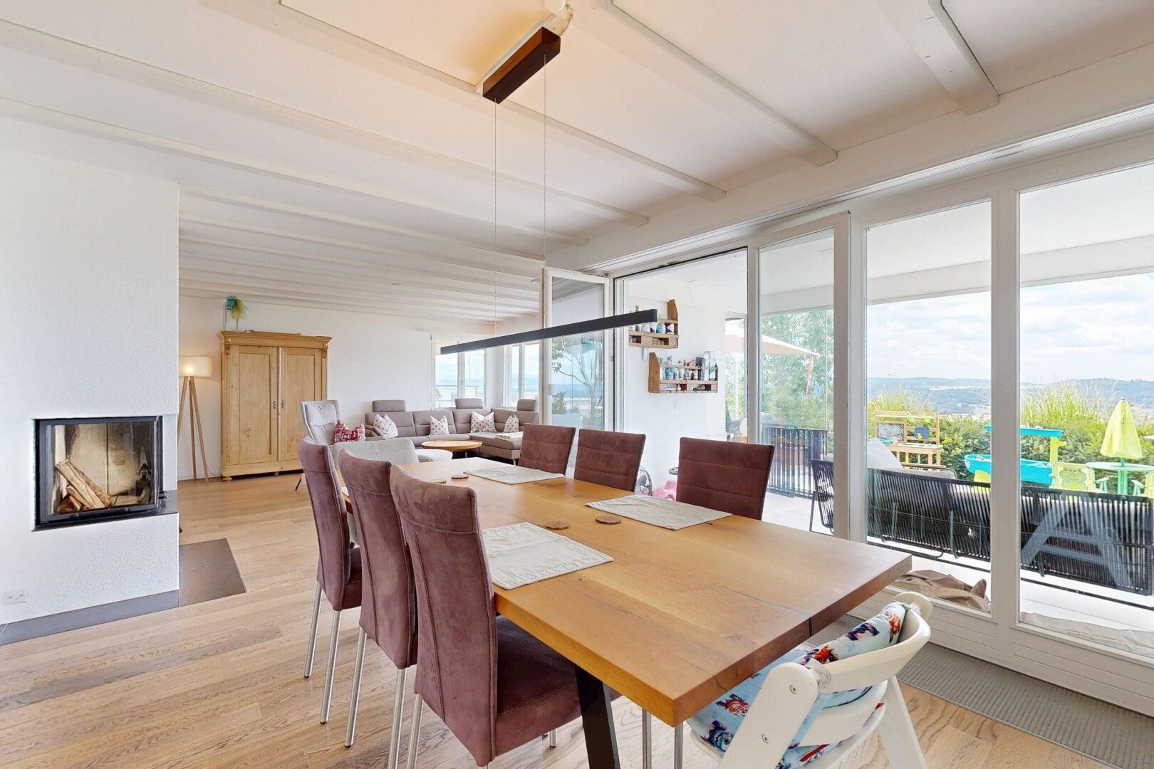 dining room with light wood finished floors and a multi sided fireplace