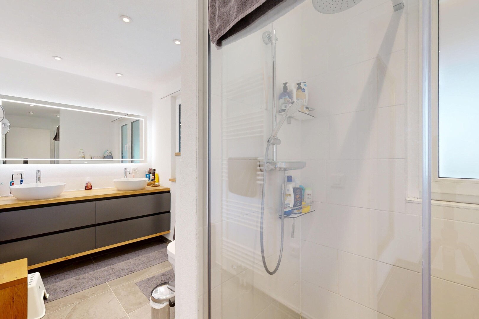 bathroom featuring a stall shower, double vanity, light tile patterned flooring, and recessed lighting