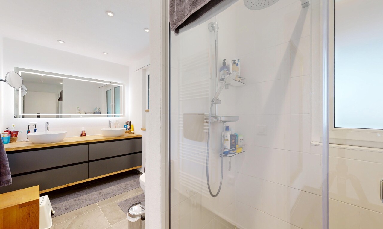 bathroom featuring a stall shower, double vanity, light tile patterned flooring, and recessed lighting