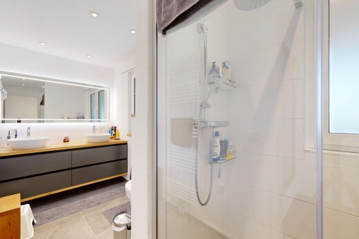bathroom featuring a stall shower, double vanity, light tile patterned flooring, and recessed lighting