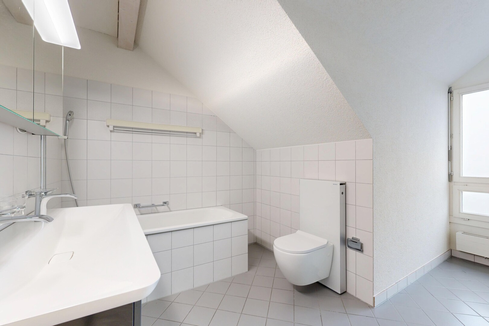 bathroom featuring tile walls, lofted ceiling, vanity, light tile patterned floors, and tiled tub