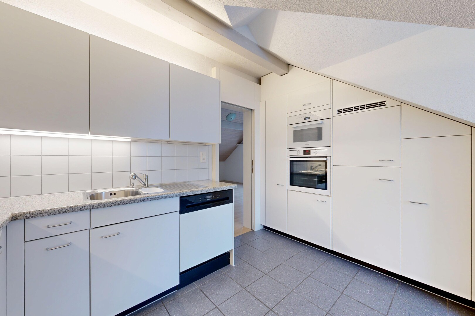 kitchen featuring light countertops, dishwasher, dark tile patterned flooring, double oven, and backsplash
