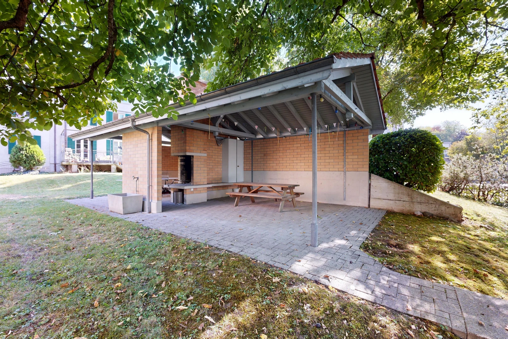 façade avec property visible, bardage en brique, pelouse, terrasse, et from property
