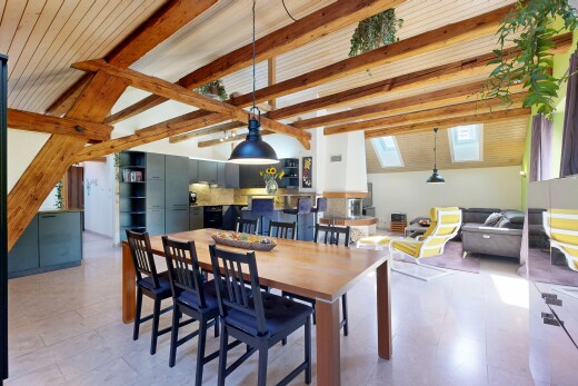 salon / salle à manger avec high end ceiling, plafond à poutres, beamed ceiling, lumière naturelle, et éclairage suspendu