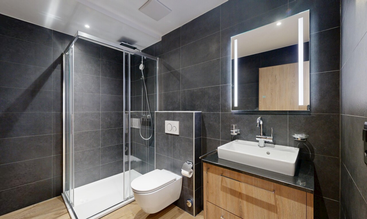 salle de bains avec tile wall, mur en carrelage, miroir, lavabo (ou coiffeuse selon le contexte), et salle de bain complète