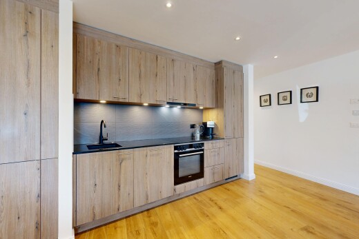 cuisine avec four, cloison sèche, drywall, inside property, et sol en finition bois