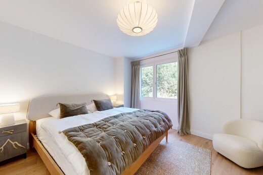 chambre avec wood finish floor, sol en finition bois, drywall, cloison sèche, et natural light