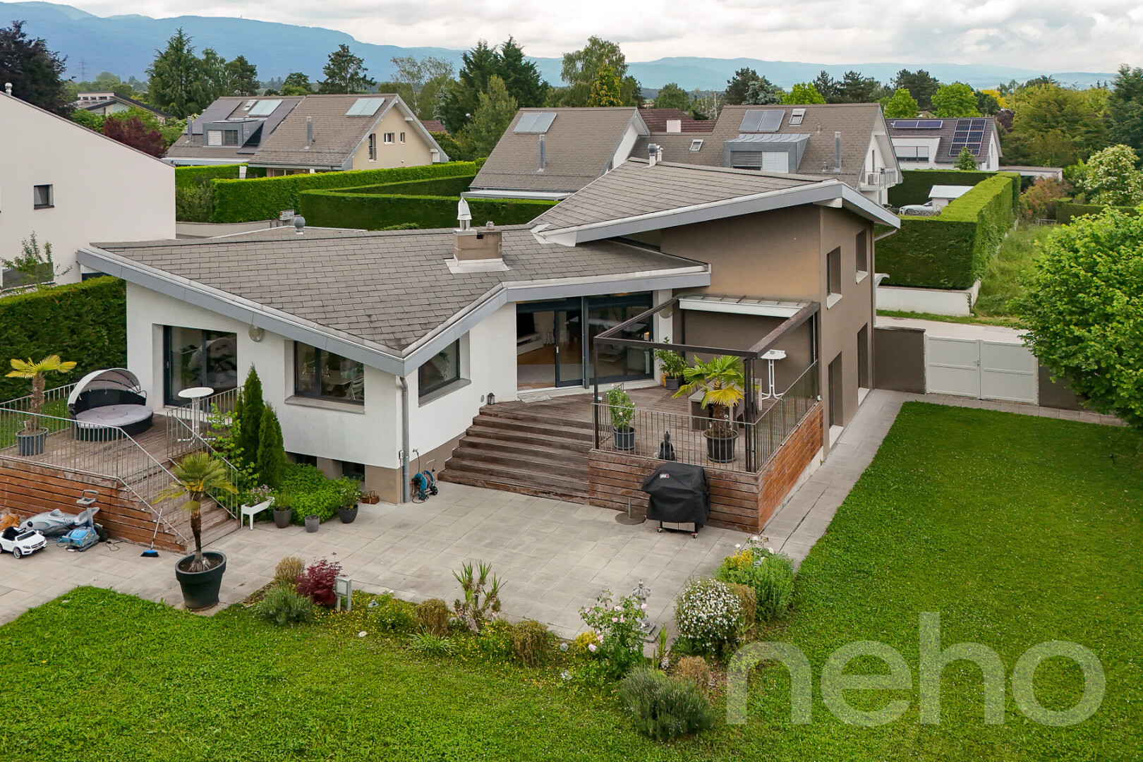 außenansicht mit terrasse, stuckverkleidung, property visible, rasen, und residential view