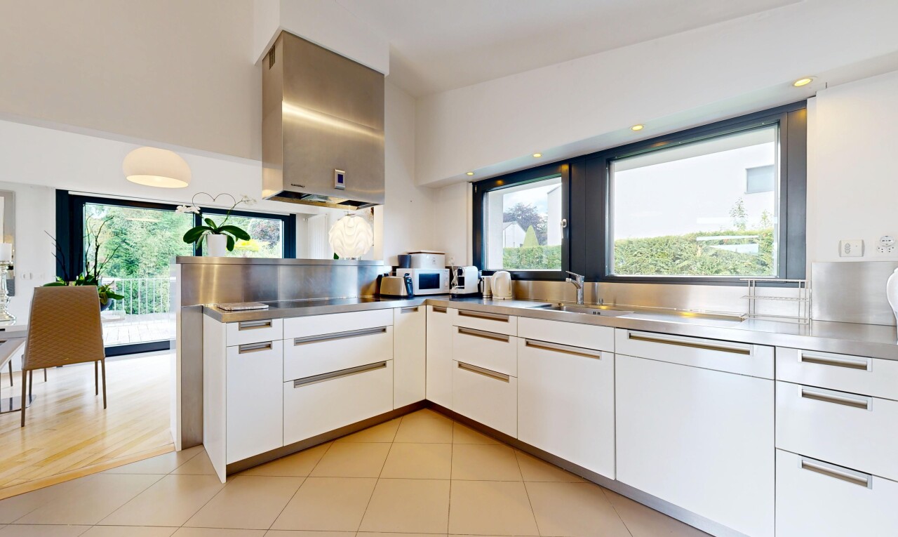 küche mit edelstahl-arbeitsplatten, waschbecken, weiße schränke, inside property, und schränke mit flachen paneelen