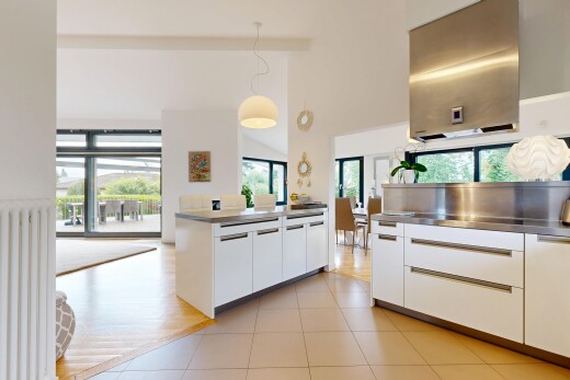 cuisine avec plafond haut, high ceiling, plans de travail en acier inoxydable, inside property, et armoires à panneau plat