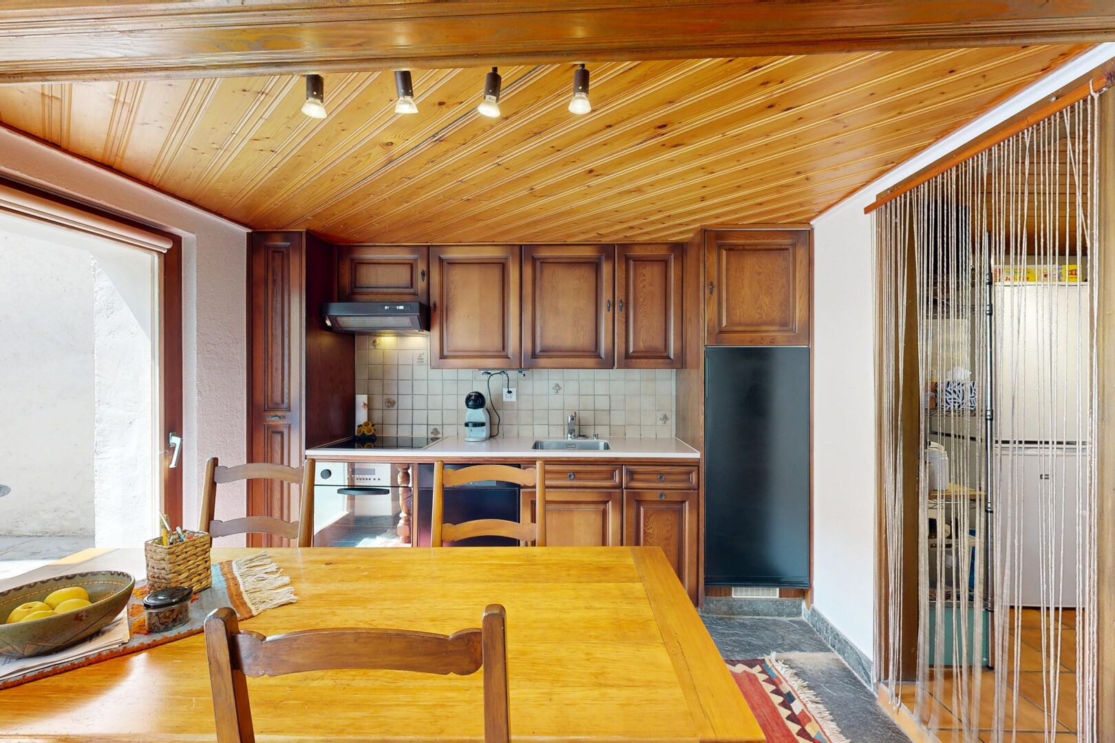 cuisine avec wood ceiling, plafond en bois, éclairage sur rail, backsplash, et dosseret