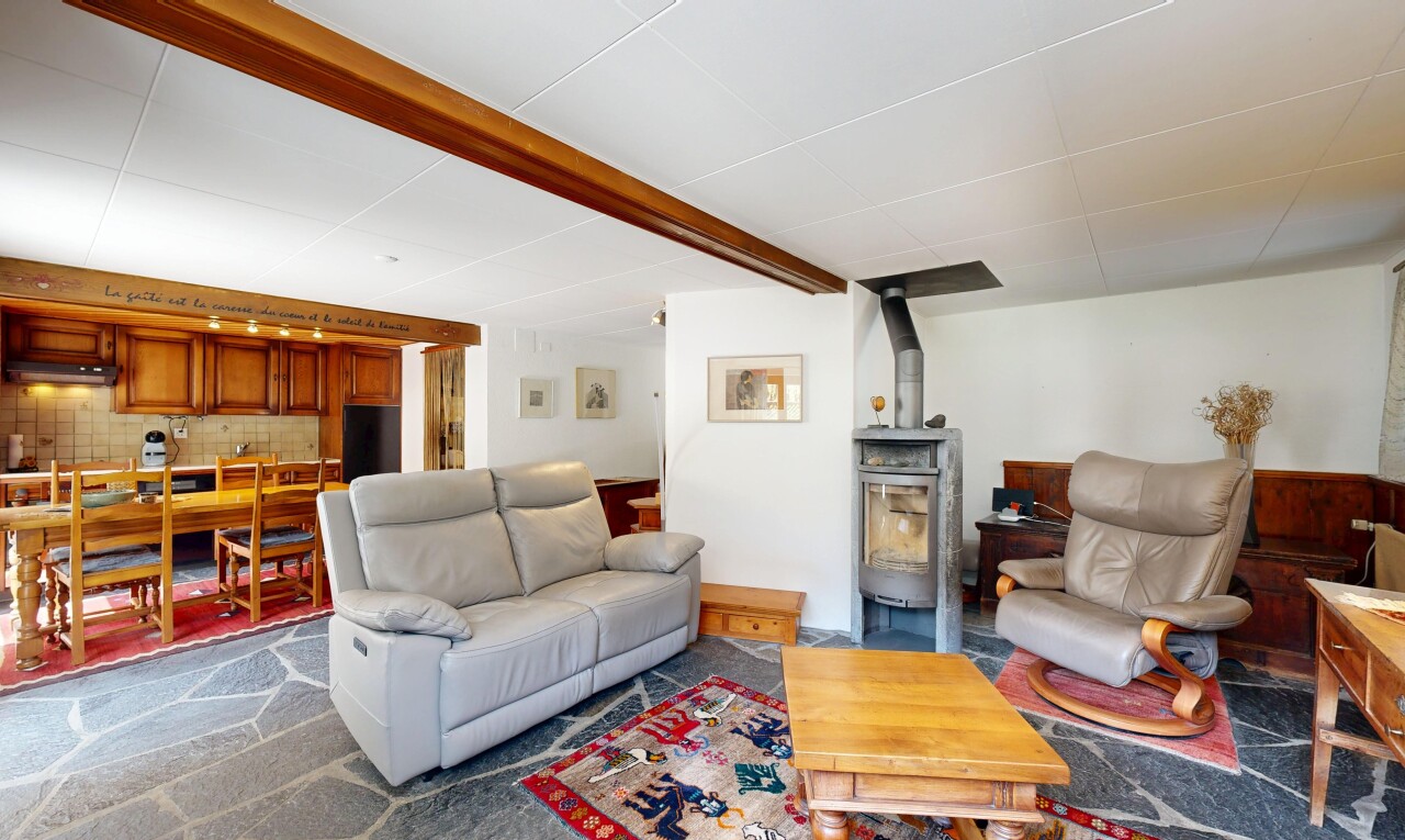 salon / salle à manger avec éclairage sur rail, drywall, cloison sèche, poêle à bois, et inside property