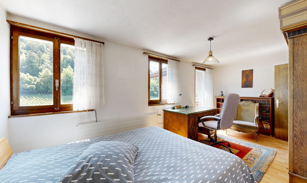 chambre avec espace bureau, cloison sèche, drywall, éclairage suspendu, et sol en finition bois