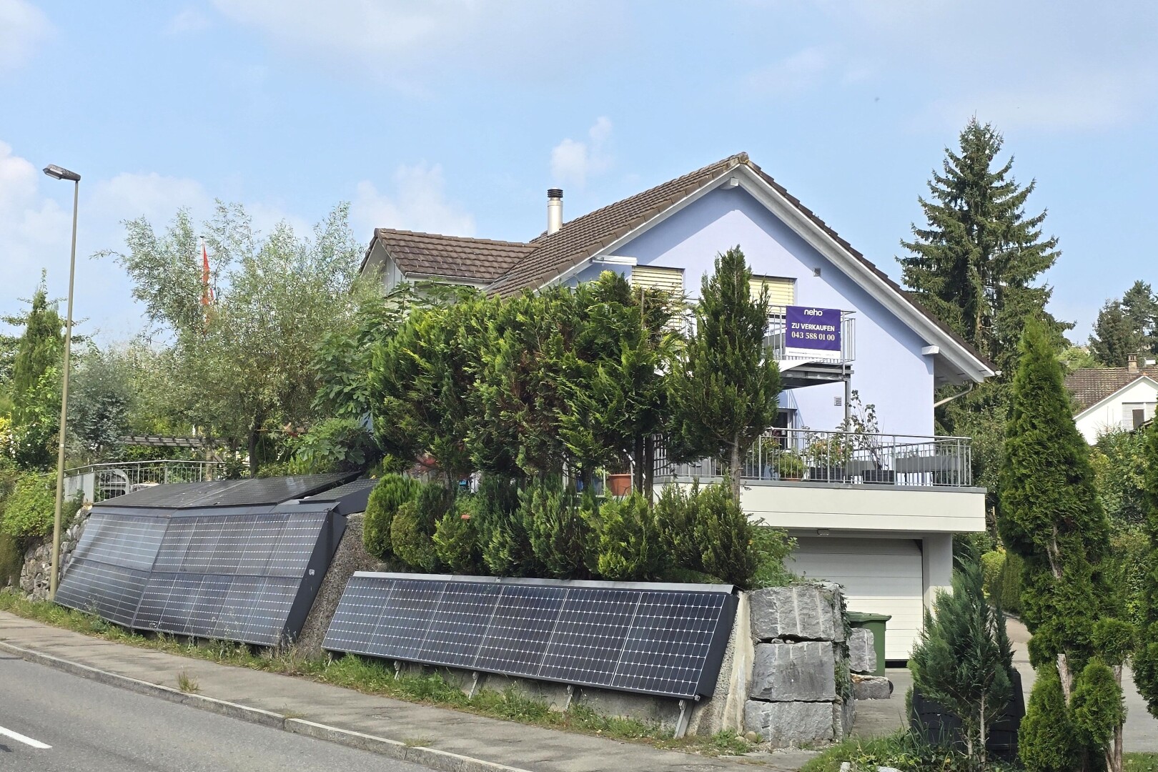 façade avec day time, garage intégré, property visible, bardage en stuc, et panneaux solaires