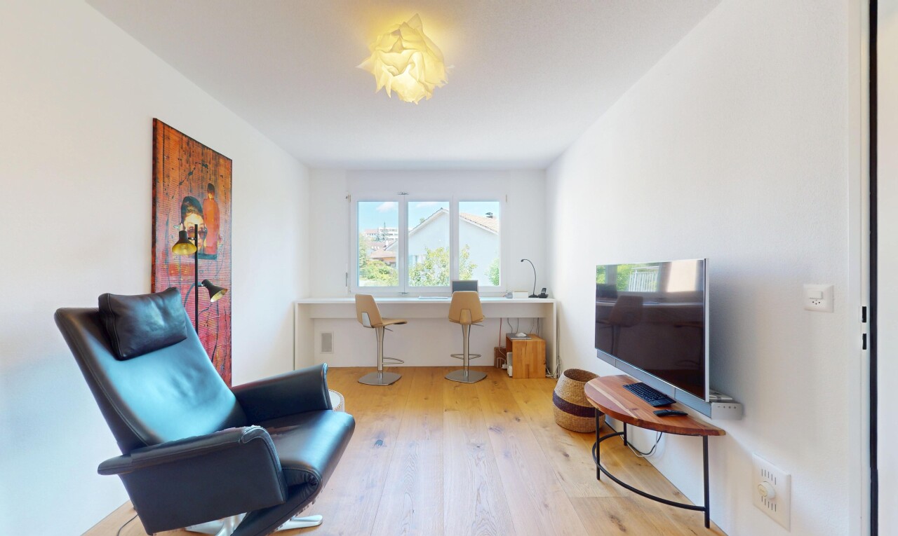 bureau avec télévision, natural light, lumière naturelle, wood finish floor, et sol en finition bois