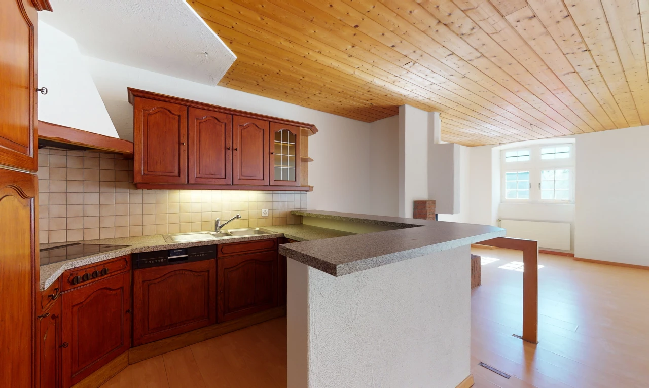 cuisine avec plafond voûté, parquet, lumière naturelle, hotte, cuisinière électrique, armoires marrons, comptoirs claires, et sol clair
