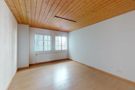chambre vide avec parquet, lumière naturelle, et radiateur